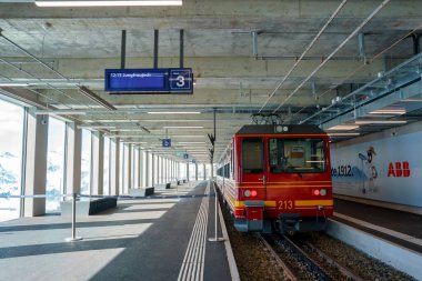 İsviçre 'deki boş Jungfrau tren istasyonuna park edilmiş kırmızı elektrikli tren, kış tatili turistler için.