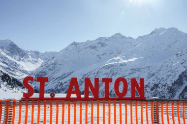 Aziz Anton, güneşli bir günde, karla kaplı dağ sırasının önündeki yazı, kış tatili konsepti.