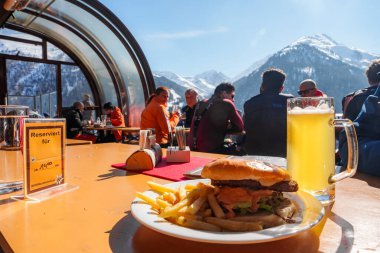 Kayak merkezinde servis edilen bira kadehli burger, kış tatili konsepti.