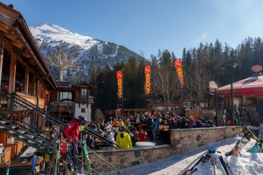 Kayak merkezinde güneşli bir günde mavi arka planda erkek ve kadın turistler, kış tatili konsepti