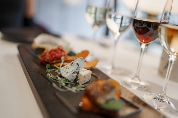 stock image Closeup of wineglasses served with various delicious appetizers on dining table at modern restaurant in luxurious hotel, luxury travel concept for tourists