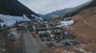 Bulutlu bir kış gününde, İtalya 'nın Tyrol kentinde, köyün ortasında çiçeklerle süslenmiş tipik ahşap bir dağ evi. Hava görünümü.