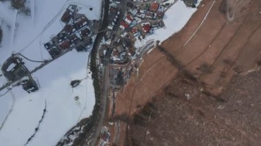 Bulutlu bir kış gününde, İtalya 'nın Tyrol kentinde, köyün ortasında çiçeklerle süslenmiş tipik ahşap bir dağ evi. Hava görünümü.
