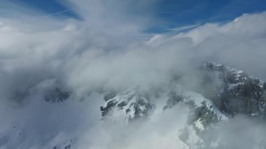 Tepeleri kar ve bulutlarla kaplı dağlık bir arazi. Ünlü St. Anton am Arlberg kayak merkezindeki dağların zirvelerini kaplayan sihirli bulutlar.