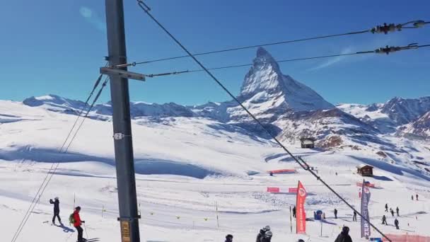 水平線のマッターホルン山頂を望む美しいツェルマットのスキーリゾート 美しいスイスアルプス マッターホルン崖と氷河の表情の魔法の景色でスキーをする人 — ストック動画