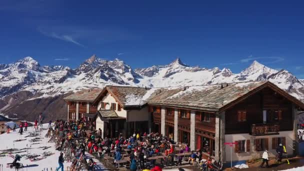 滑雪者和滑雪者在酒吧外享受Zermatt滑雪派对 在雪地的阿尔卑斯山斜坡的背景下坐上椅子 — 图库视频影像