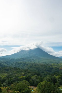 Bulutlu volkanik arka planıyla Kosta Rika 'nın muhteşem manzarası. Volkan Arenal 'in panoraması, La Fortuna, Kosta Rika' daki muhteşem pitoresk gölü yansıttı. Orta Amerika.
