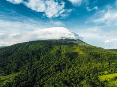 Bulutlu volkanik arka planıyla Kosta Rika 'nın muhteşem manzarası. Volkan Arenal 'in panoraması, La Fortuna, Kosta Rika' daki muhteşem pitoresk gölü yansıttı. Orta Amerika.