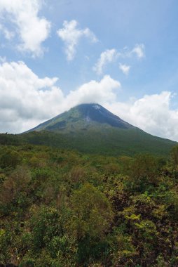 Bulutlu volkanik arka planıyla Kosta Rika 'nın muhteşem manzarası. Volkan Arenal 'in panoraması, La Fortuna, Kosta Rika' daki muhteşem pitoresk gölü yansıttı. Orta Amerika.