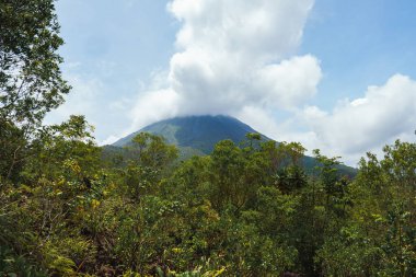 Bulutlu volkanik arka planıyla Kosta Rika 'nın muhteşem manzarası. Volkan Arenal 'in panoraması, La Fortuna, Kosta Rika' daki muhteşem pitoresk gölü yansıttı. Orta Amerika.