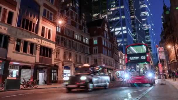 在伦敦利物浦车站附近的一条繁忙的道路上 夜幕降临 汽车和公共汽车成群结队地驶过 身后是著名的摩天大楼 — 图库视频影像