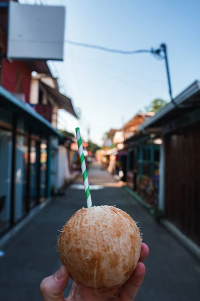 Closeup Hand Holding Refreshing Coconut Drinking Straw Main Street Village — Stock Photo, Image