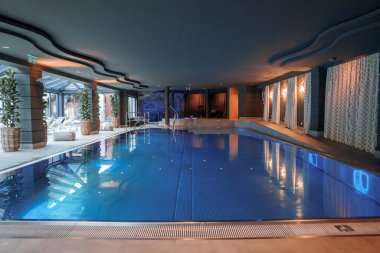 Lüks modern otelin iç tasarımı. Odanın ortasında yüzme havuzu, turistler için lüks tatil ve tatil konsepti bulunuyor.