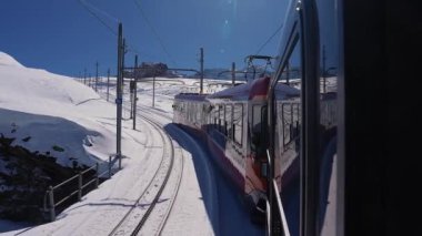 İsviçre 'nin Valais Alplerindeki Zermatt kayak merkezindeki ikonik çarklı Gornergrat trenine binmek güneşli bir kış gününde İsviçre' de trene binmek.