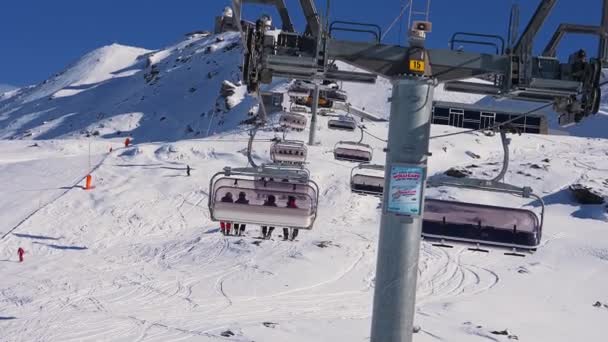 滑雪椅升降 俯瞰山顶和斜坡 美丽的滑雪胜地 雪下后 阳光灿烂 滑雪板小木屋运送滑雪者和滑雪者 — 图库视频影像