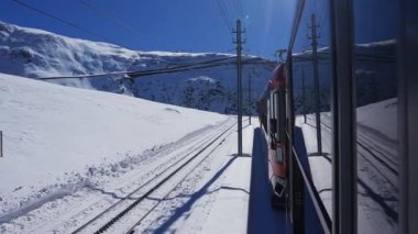 İsviçre 'nin Valais Alplerindeki Zermatt kayak merkezindeki ikonik çarklı Gornergrat trenine binmek güneşli bir kış gününde İsviçre' de trene binmek.