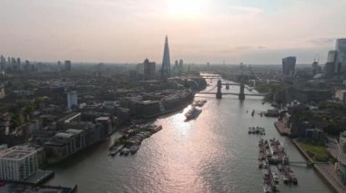 Londra üzerinde ikonik Tower Bridge manzaralı ve Londra 'daki şehir merkezinin ufuk çizgisi olan güzel bir gün batımı..