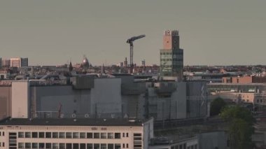 Riga, Letonya 'da yaz günbatımı. Gün batımında Letonya 'nın başkenti Riga' nın hava manzarası. Şehirden geçen güzel binalar, köprüler ve nakliye araçları.