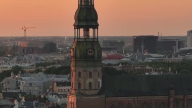 Riga, Letonya 'da yaz günbatımı. Gün batımında Letonya 'nın başkenti Riga' nın hava manzarası. Şehirden geçen güzel binalar, köprüler ve nakliye araçları.