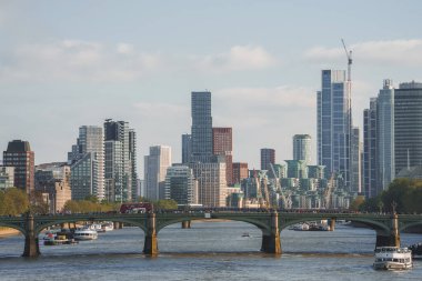 Şehirdeki Thames nehri üzerindeki Westminster Köprüsü manzarası. Arka planda gökyüzü olan modern binalara uzaktan bakmak. Londra başkentinin manzaralı şehir güzelliği.