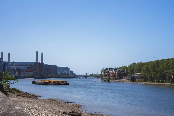 泰晤士河河岸的Battersea电站 小船停泊在水面上 背景为蓝天 阳光普照的城市自然景观 — 图库照片