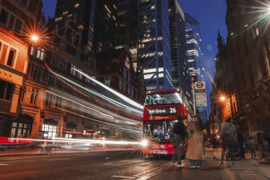 Kırmızı çift katlı otobüsle trafik ışıklarına uzun süre maruz kaldık. Şehir merkezindeki durakta durdular. Şehir merkezindeki modern ofis binaları. Londra şehrindeki işlek cadde manzarası.