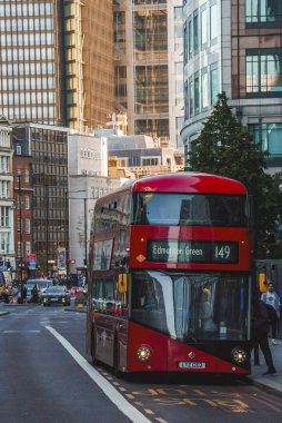 Finans bölgesinde kırmızı çift katlı otobüs parketmiş. Şehir merkezindeki modern ofis binaları. Londra şehrindeki işlek cadde manzarası.