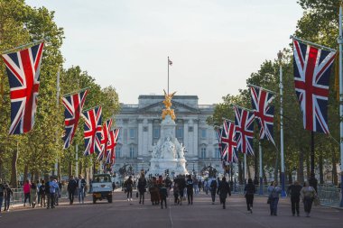 Buckingham Sarayı 'nın önündeki Kraliçe Victoria anıtı. Güneşli bir günde Londra 'nın ikonik sembolü. İnsanlar tatilde ünlü heykel başında boş vakitlerini geçiriyorlar.