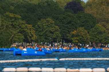 Erkek ve dişi turistler sandallarda oturuyorlar. Londra 'daki Hyde Park' ta yılan gölü. İnsanlar yaz tatilinde eğleniyor.