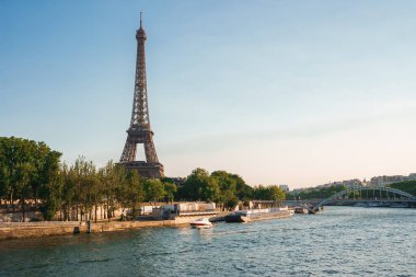 Eiffel Kulesi 'nin geniş açılı görüntüsü Seine Nehri' nden sabah güneşli mavi bir gökyüzünün altında..