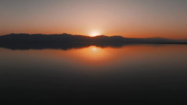 Deniz üzerinde günbatımı ufkunun havadan görünüşü. Sinema insansız hava aracı manzarası güzel bir akşam güneşi denizin üzerinde. Güneş yolu deniz yüzeyine yansır. Doğa güzelliği.