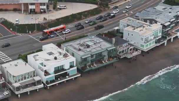 カリフォルニア州マリブビーチ海岸の4K空中ドローンショット 青い太平洋と波が入って来て バックグラウンドに素敵な家とビーチ — ストック動画