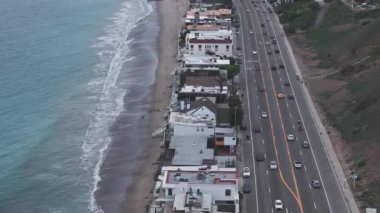 California 'daki Malibu sahilinin 4K hava aracı görüntüsü. Mavi Pasifik Okyanusu, dalgalar geliyor ve arka planda güzel evler var..