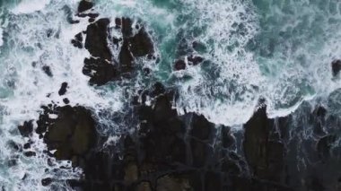 Pasifik Okyanusu 'nun hava manzarası kayalara çarpıyor. Dalgaların en üst görüntüsü. Fırtına sırasında deniz kıyısı.