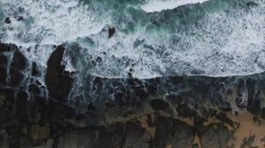 Pasifik Okyanusu 'nun hava manzarası kayalara çarpıyor. Dalgaların en üst görüntüsü. Fırtına sırasında deniz kıyısı.
