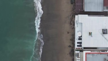 California 'daki Malibu sahilinin 4K hava aracı görüntüsü. Mavi Pasifik Okyanusu, dalgalar geliyor ve arka planda güzel evler var..
