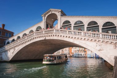 Venedik, İtalya 'daki Iconic Rialto Köprüsü' nden geçen bir teknesi var. Huzur ve sükuneti çağrıştırıyor. Çevredeki binalar görünmüyor. Vantage noktası ve tekne tipi belirtilmemiş.