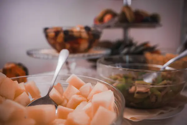 A delicious buffet spread with a variety of food items including melon, cheese, and crackers. The specific types of cheese and crackers are unknown.