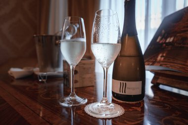 Venedik, İtalya 'da lüks bir restoran veya otelde gösterilen zarif ve sofistike bir Venedik tarzı. Görüntü, iki şarap bardağı ve açılmamış bir şişe şarapla dolu bir masa içeriyor..