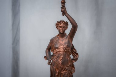 Bronz heykel, elinde meşale tutan kadın heykeli. Heykel yeri ve giysisi bilinmiyor. SEO: bronz heykel, kadın figürü, meşale taşıyıcısı, sanat, anıt, tarihi eser, simge.