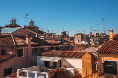 İtalya, Venedik 'in turuncu çatılarının sakin bir gündüz görüntüsü kendine özgü mimari özellikler sergiliyor ve dinginlik ve çekicilik hissi veriyor..