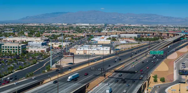 stock image Aerial view of a southwestern U.S. cityscape with a busy highway interchange, modern buildings, mountain backdrop, and clear blue skies in Las Vegas, USA.