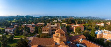 Güneşli bir günde yeşil çimenler ve ağaçlar arasında kırmızı tuğla, Gotik ve modern binaların yer aldığı Westwood, Los Angeles 'taki UCLA kampüsünün hava manzarası..