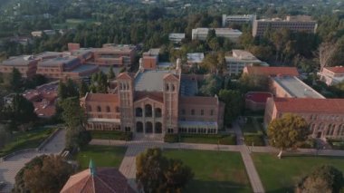 UCLA kampüsünün havadan görünüşü Royce Hall 'un merkez sahnesi, Romanesk mimarisi, yeşil alanlar, ve Westwood kentsel zemin altın sabah - öğleden sonra ışığı.
