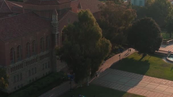 美国加州大学洛杉矶分校校园的空中景观 以罗伊斯大厅为中心舞台 罗曼式建筑 以及金光闪闪的晨光下的威斯特伍德都市背景 — 图库视频影像