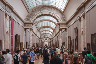 Sırt çantalı geniş bir grup insan Rönesans tarzı bir müzeyi keşfediyorlar..