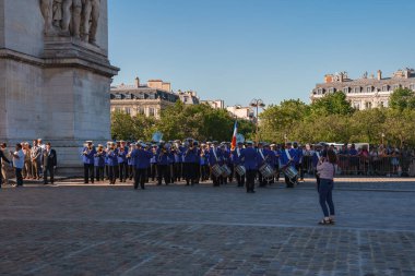 Güneşli bir günde Paris 'te Zafer Takı önünde poz veren 20 kişilik bir grup..