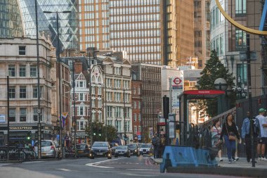 Turistler kaldırımda yürürken arabalar yolda ilerliyor. Londra 'nın finans bölgesindeki ofis binaları. Londra 'yı keşfeden kadın ve erkekler.