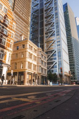 Bishopgate ve Heron kulesinin orada yürüyen turistler var. Şehir merkezinde erkek ve kadınlar keşfe çıkıyor. Güneşli bir günde Londra 'da ünlü bir eğlence..