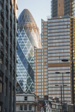 Şehrin finans bölgesindeki Gherkin. Arka planda gökyüzü olan modern ofis binaları. Güneşli bir günde Londra şehir merkezindeki ünlü turistik eğlence merkezi..